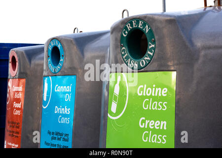 Les bacs de recyclage de verre de différentes couleurs avec l'écriture irlandaise Banque D'Images