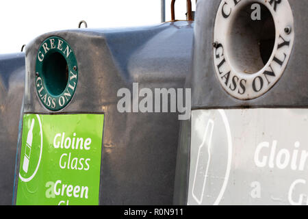 Les bacs de recyclage de verre de différentes couleurs avec l'écriture irlandaise Banque D'Images