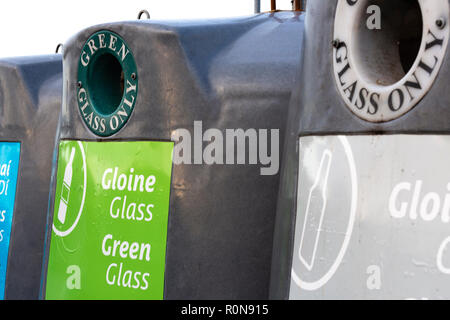 Les bacs de recyclage de verre de différentes couleurs avec l'écriture irlandaise Banque D'Images