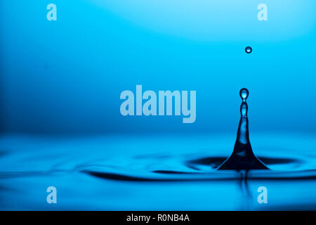 Slow motion photographie de l'eau qui goutte dans une flaque d'eau. À l'aide flash haute vitesse pour capturer la beauté de la liste déroulante. Banque D'Images