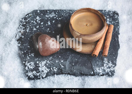 Tasse à expresso avec décoration d'hiver et d'Épice en forme de cœur sur la neige Banque D'Images