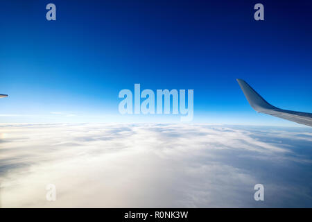 Ailes d'un avion volant au-dessus des nuages de la belle. Banque D'Images