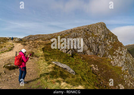 Une femme prend une photo sur son téléphone portable sur Cadair Idris dans le parc national de Snowdonia, Pays de Galles, Royaume-Uni Banque D'Images