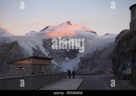 Deux alpinistes de commencer la journée à jusque Franz-Josefs-Höhe avec sunrise sur Mt. Le johannisberg et son glacier, le parc national du Hohe Tauern, l'Autriche Banque D'Images