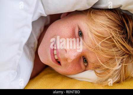 Portrait of a smiling boy Lying in Bed Banque D'Images