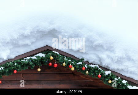 Toit en bois recouvert de neige avec de branches d'épinette et colorée des jouets de Noël Nouvel an et de décorations. Fond d'hiver naturelles. Banque D'Images