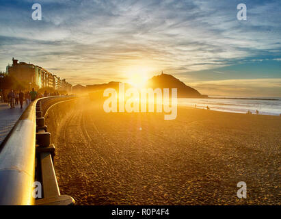 Le soleil se couche derrière le Monte Urgull de San Sebastian, Pays Basque, Guipuzcoa. L'Espagne. Vue de la plage de Zurriola. Banque D'Images