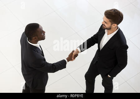 Vue de dessus de la diversité des employés masculins handshake talking in hallway Banque D'Images