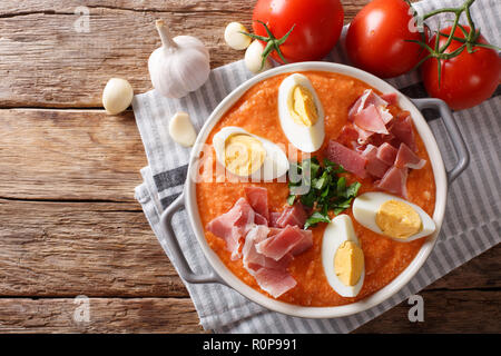 L'été frais Antequera Porra soupe de tomates, poivrons et l'ail servi avec des oeufs durs et du jambon libre dans une casserole sur la table horizontale f Vue de dessus. Banque D'Images