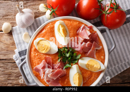 Purée de légumes traditionnels Porra antequera soupe avec oeufs durs et du jambon serrano close-up sur la table. Haut horizontale Vue de dessus Banque D'Images