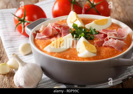 Purée de légumes traditionnels Porra antequera soupe avec oeufs durs et du jambon serrano close-up sur la table horizontale. Banque D'Images