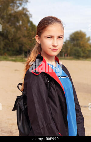 Adolescentes dans un imperméable et un sac à dos avec des promenades dans le parc en automne Banque D'Images