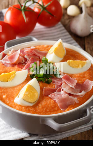 Soupe froide espagnol Antequera Porra fabriqué à partir de tomates, le poivre et l'ail servi avec des oeufs durs et du jambon dans une casserole sur la table horizontale. Banque D'Images