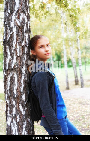 Dans l'humeur romantique une fille de l'adolescence dans un automne Birch Grove. Une sorte d'oeil moqueur et légèrement dans l'appareil photo, soft focus Banque D'Images