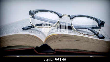 Verres vintage sur un livre isolé sur fond blanc Banque D'Images