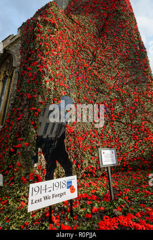Sudbury, Suffolk, UK, 6e Novemebr 2018 le filet de coquelicots en tricot qui couvrent l'église St Pierre à Sudbury, Suffolk, qui ont à mailles. Un total de plus de 17 000 coquelicots ont été cousues à un filet de 90 pieds. Le filet a été placé sur le churhc tower et cascade vers le bas dans les jardins ci-dessous à l'occasion du 100e anniversaire de la fin de la Première Guerre mondiale. Photo : Mark Bullimore Photography/Alamy Live News Banque D'Images