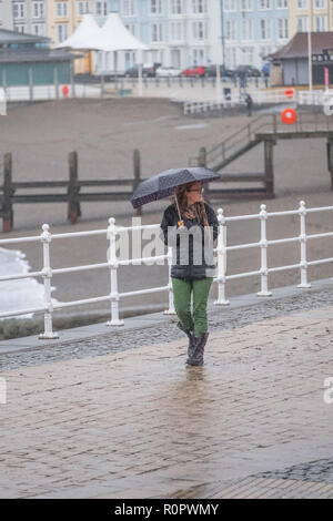 Aberystwyth, Pays de Galles, Royaume-Uni. 7 novembre, 2018. Météo France : Les gens marcher sous la pluie sur une très humide , mais doux, matin à Aberystwyth. Le Met Office a émis une alerte jaune pour la pluie et les inondations couvrant une grande partie de l'ouest du pays de Galles et du sud ce matin, avec un avertissement supplémentaire pour plus de pluie et de forts coups de vent émis pour la même zone le vendredi aussi. Crédit photo : Keith Morris/ Alamy Live News Banque D'Images