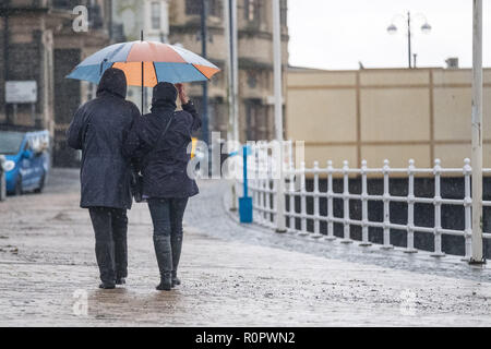 Aberystwyth, Pays de Galles, Royaume-Uni. 7 novembre, 2018. Météo France : Les gens marcher sous la pluie sur une très humide , mais doux, matin à Aberystwyth. Le Met Office a émis une alerte jaune pour la pluie et les inondations couvrant une grande partie de l'ouest du pays de Galles et du sud ce matin, avec un avertissement supplémentaire pour plus de pluie et de forts coups de vent émis pour la même zone le vendredi aussi. Crédit photo : Keith Morris/ Alamy Live News Banque D'Images