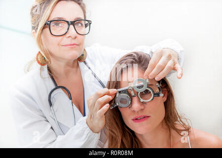 Spécialiste en ophtalmologie à l'essai de nouvelles lentilles sur un patient avec phoropter Banque D'Images