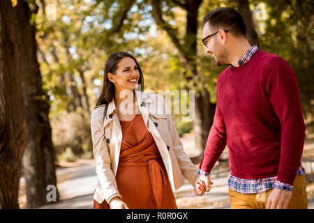 Charmante jeune couple en train de marcher dans le parc en automne Banque D'Images