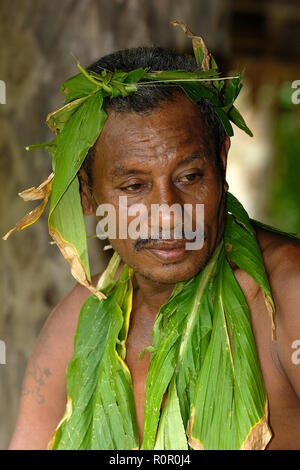 Einheimischer Mann Palmblättern, geschmückt mit Porträt, Yap, Mikronesien | homme portant des feuilles de palmier, transpiration, portrait, Yap, Micronésie Banque D'Images