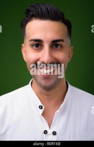 Beau jeune homme iranien avec moustache contre green backgroun Banque D'Images