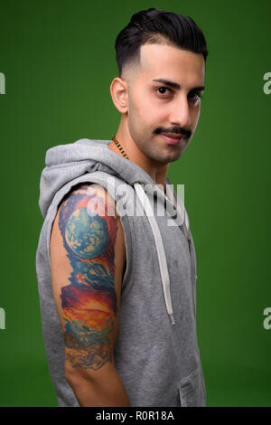 Beau jeune homme iranien avec moustache contre green backgroun Banque D'Images