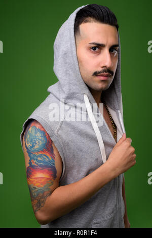 Beau jeune homme iranien avec moustache contre green backgroun Banque D'Images