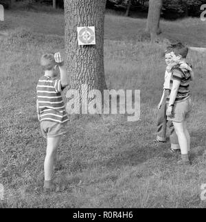 Activité de l'été dans les années 50. Trois garçons jouent aux fléchettes à l'extérieur. La Suède 1957 Ref 3480 Banque D'Images