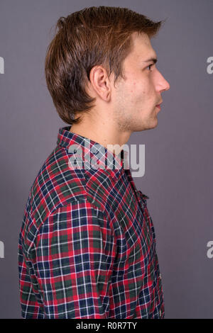 Portrait de jeune homme séduisant contre l'arrière-plan gris Banque D'Images