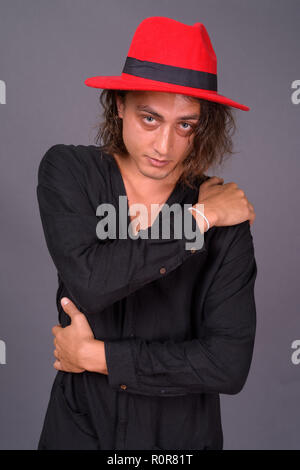 Portrait de jeune homme séduisant contre l'arrière-plan gris Banque D'Images