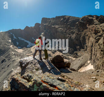 Deux voyageurs anonymes debout sur rock rugueux et admirer la vue pittoresque des montagnes majestueuses de la Sierra Nevada, Granada, Espagne Banque D'Images