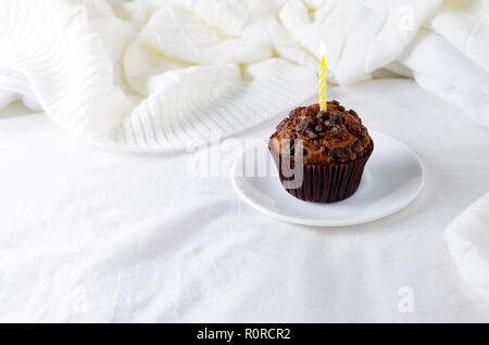 Muffins ou capkakes avec du chocolat et du café noir sur un plateau en bois au lit. Arrière-plan blanc. Un aliment sucré. Ambiance de fête copie espace télévision lay Banque D'Images