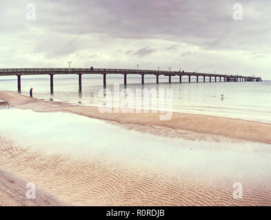 Pont au-dessus de la mer Baltique. Bien caché dans l'horizon brumeux, des reflets violets dans l'eau. Banque D'Images