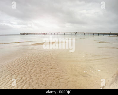 Pont au-dessus de la mer Baltique. Bien caché dans l'horizon brumeux, des reflets violets dans l'eau. Banque D'Images