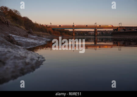 Une côte ouest Virgin Trains Pendolino crossing Bridge Carlisle, Lancaster reflète dans l'eau de la rivière Lune Banque D'Images