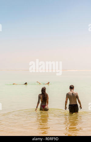 Deux personnes se baigner dans la mer Morte, enduit de boue, Ein Bokek, Dead Sea, Kalia Beach, Israël Banque D'Images