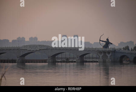 WUHAN HUBEI/ CHINE - OCT 04 2018 : Très beau coucher du soleil à Wuhan et ancienne statue. Et avec l'arche du pont. Banque D'Images