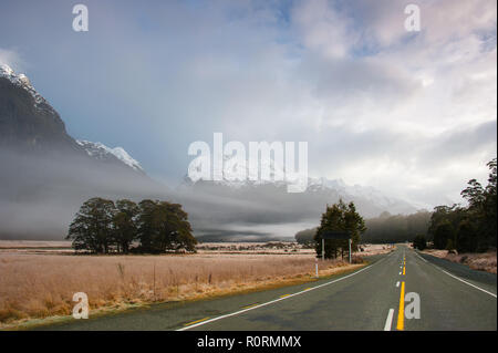 Lever de soleil à Fiordland, Nouvelle-Zélande. Les brouillards accrocher au-dessus de la vallée, avec une montagne et ciel nuageux fond. Banque D'Images