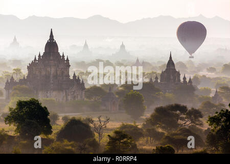 Les montgolfières survolant pagodes à misty dans la plaine de Bagan, Myanmar (Birmanie) Banque D'Images