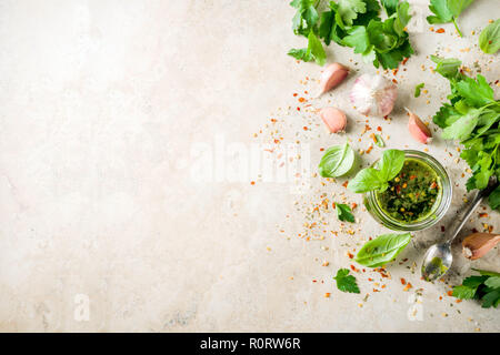 Les aliments, les matières traditionnelles argentines vert fait maison ou une sauce salsa Chimichurri avec le persil, l'ail, les feuilles de basilic, le piment et les épices, l'onglet de la pierre de lumière Banque D'Images