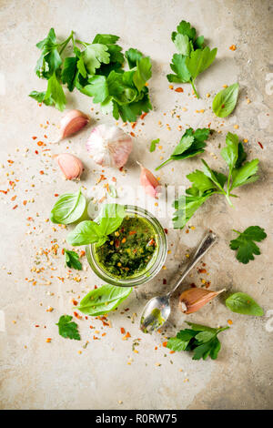 Les aliments, les matières traditionnelles argentines vert fait maison ou une sauce salsa Chimichurri avec le persil, l'ail, les feuilles de basilic, le piment et les épices, l'onglet de la pierre de lumière Banque D'Images