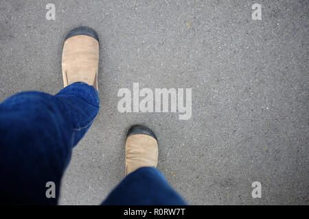 Chaussures homme en daim marron et bleu jeans la marche sur la voie du succès. Banque D'Images