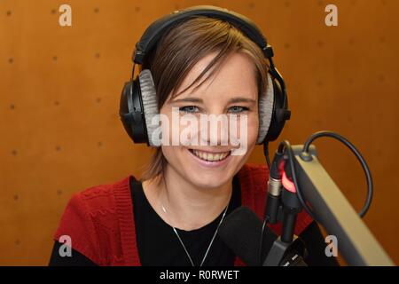 Journaliste Femme portant des écouteurs et à l'aide d'un micro pour parler à la radio Banque D'Images