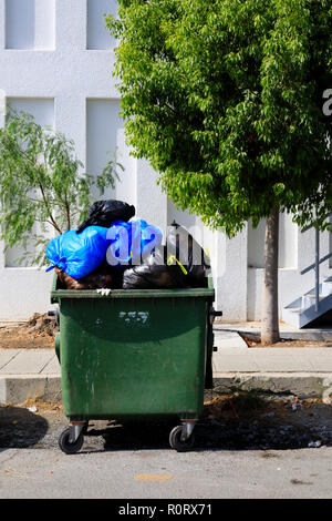 Des sacs poubelle débordant dans un aller dans la rue, Larnaca, Chypre Octobre 2018 Banque D'Images