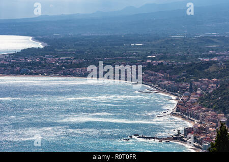 Au-dessus de la côte de la mer Ionienne et la ville de Taormina Giardini Naxos ville, Sicile, Italie. Banque D'Images