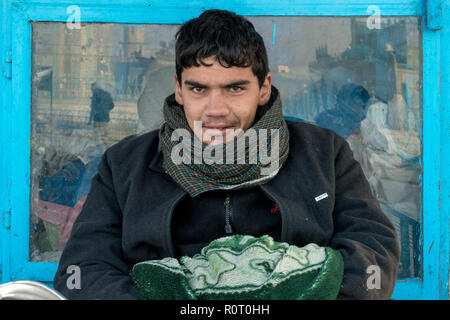 Jeune homme la vente de graines pour nourrir les pigeons blancs saint en dehors du tombeau de Hazrat Ali, également appelée la Mosquée Bleue, Mazar-e Sharif, Afghanistan Banque D'Images