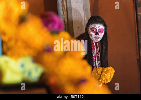 Un Mexicain girl wearing skeleton face paint vues ofrenda autels pendant les morts de la fête des morts à San Miguel de Allende, Mexique. Le festival de plusieurs jours est de se souvenir de leurs amis et les membres de leur famille qui sont morts à l'aide de comté, aztec tagètes, alfeniques, papel picado et les aliments et boissons préférés des défunts. Banque D'Images