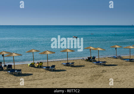 Paysage méditerranéen avec parasols et chaises longues dans le fond bleu du ciel Banque D'Images