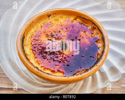 Crème catalane ou crème brûlée dans un bol rustique, typique taberna bistro ou présentation avec un bâton de cannelle dans le milieu. Crème catalane ou crème brûlée dans un bol rustique, typique taberna bistro ou présentation avec un bâton de cannelle dans le milieu.